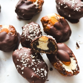 Chocolate-covered dates stuffed with a creamy filling and topped with whole almonds and shredded coconut,