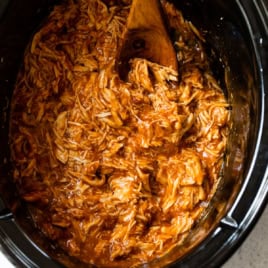Crockpot BBQ chicken with wooden spoon