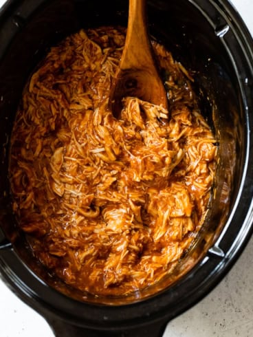 Crockpot BBQ chicken with wooden spoon