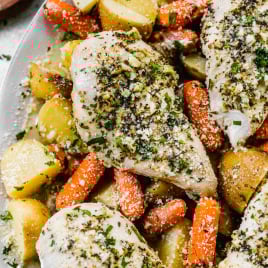 chicken breasts a top potatoes and carrots with a sprinkle of parmesan and herbs