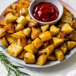 Serving bowl of oven-roasted potatoes with rosemary