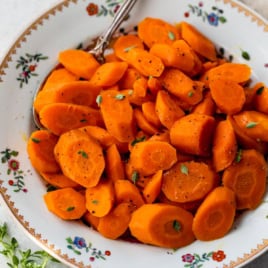 Tender sauteed carrots in bowl with spoon