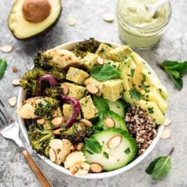 a roasted veggie buddha bowl with tahini dressing, tofu and quinoa