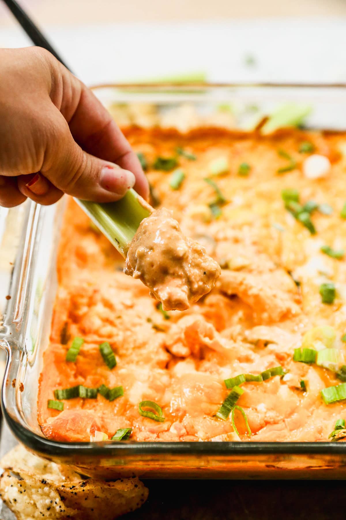 Dipping celery into healthy Buffalo chicken dip