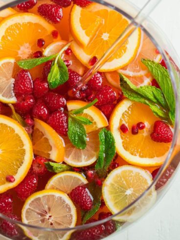 A glass bowl of champagne punch with fruit