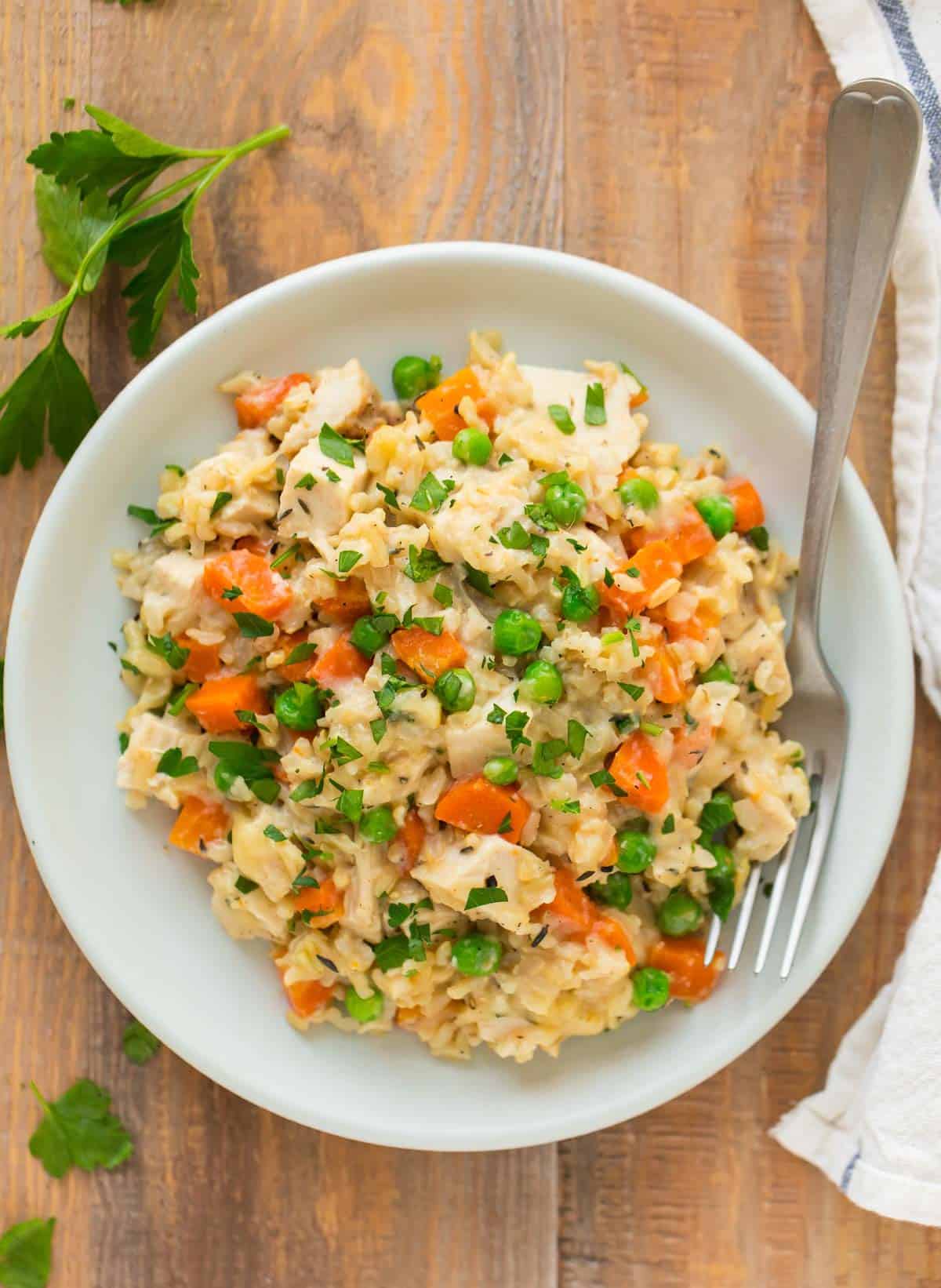 A white plate with healthy crock pot chicken and rice