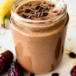 A glass jar filled with a creamy chocolate coffee smoothie