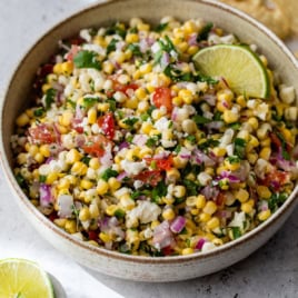 Bowl of corn salsa with lime wedge