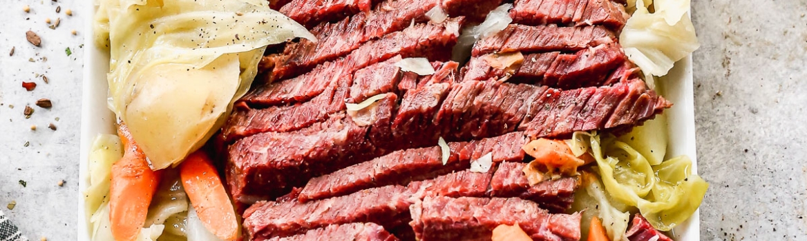 A platter of corned beef brisket with cabbage wedges