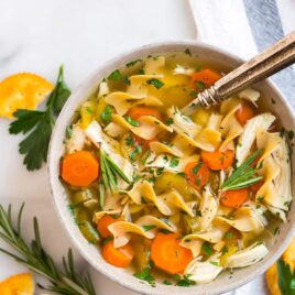 Crock pot chicken noodle soup in a white bowl