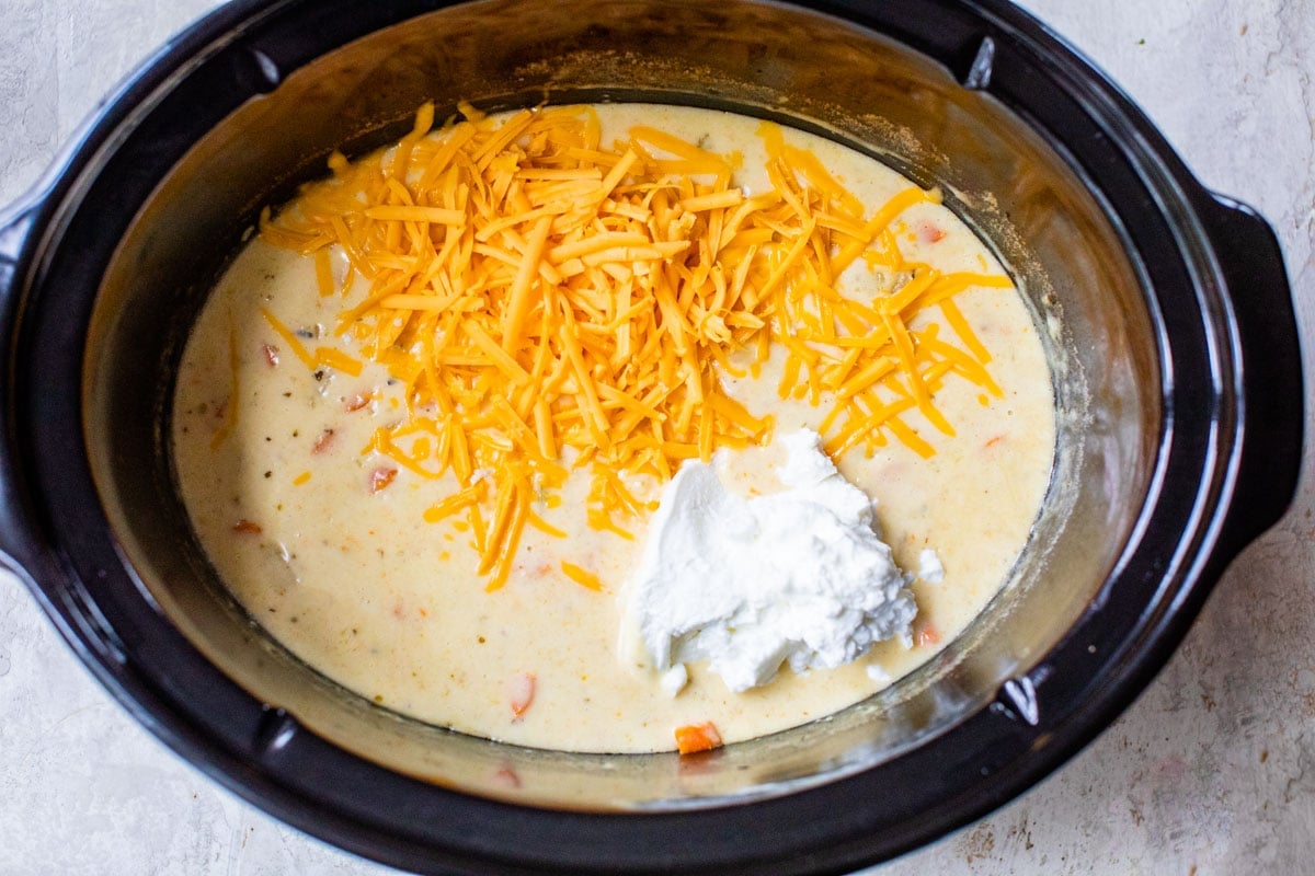 stirring greek yogurt and cheese into easy crockpot potato soup