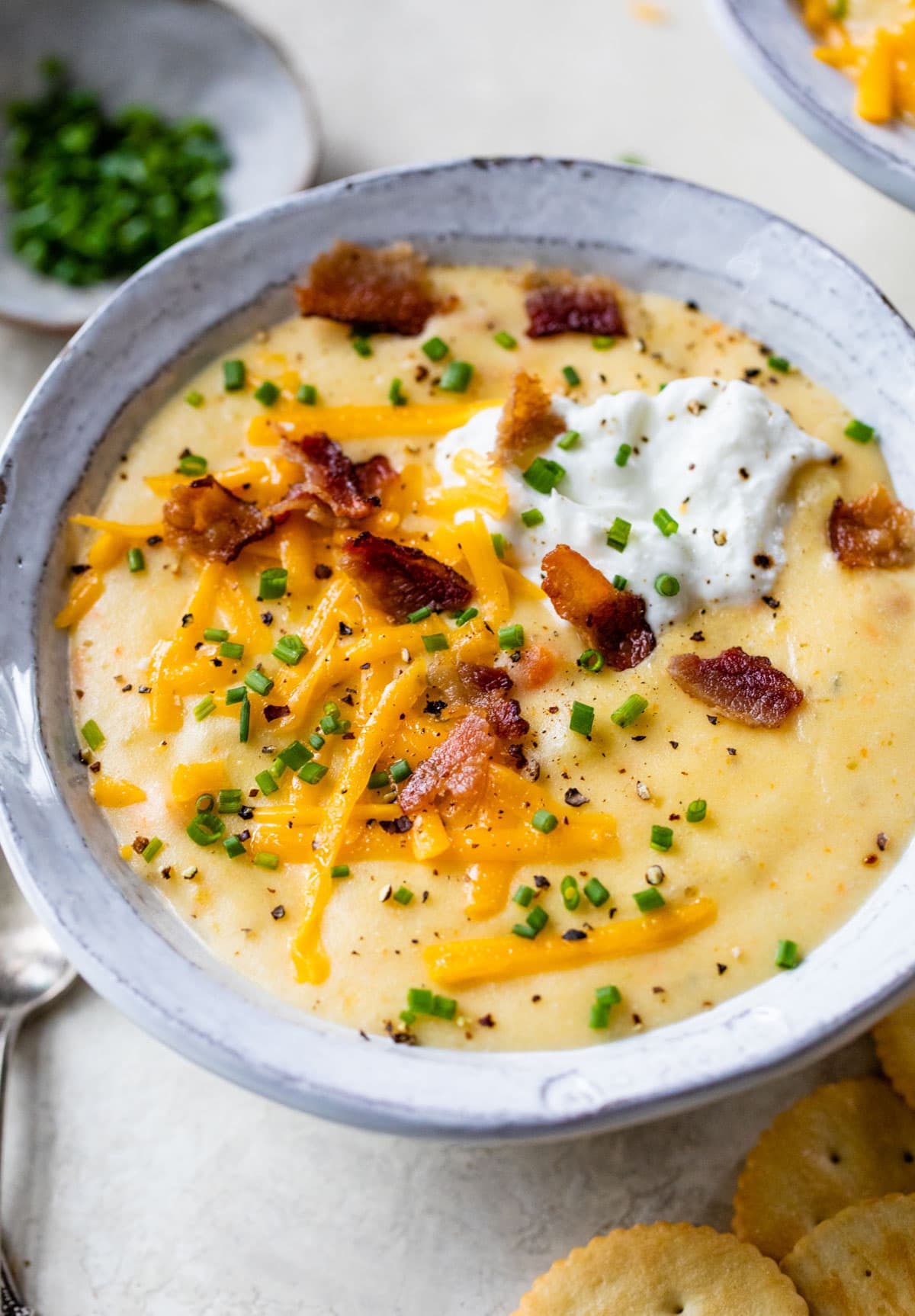 a bowl of the easiest crockpot potato soup topped with cheese and bacon