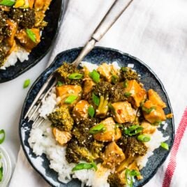 A plate with slow cooked chicken and steamed broccoli florets in an Asian ginger sauce