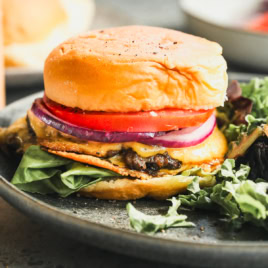 a double stacked smash burger on a bun with cheese, lettuce, and tomato