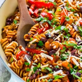 Creamy eggplant pasta with a wooden spoon in a skillet