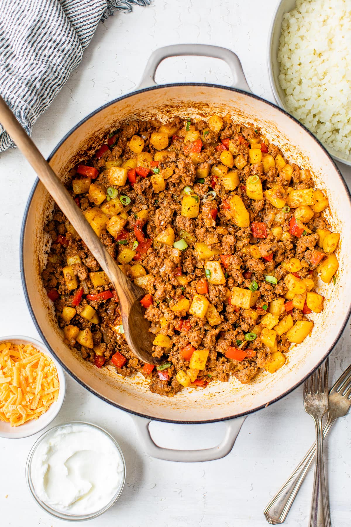 Ground beef and potatoes being stirred in a pot