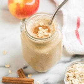 A mug with a creamy vegan apple smoothie with banana, oatmeal, and cinnamon