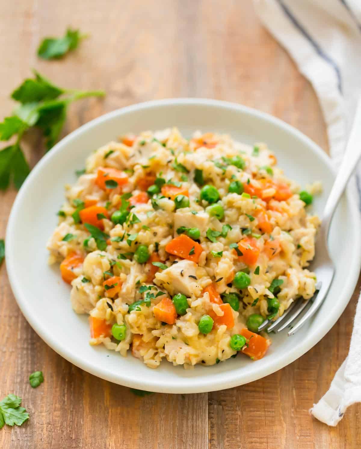 A plate of crock pot chicken and rice with vegetables