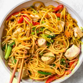 A bowl of chicken chow mein with chopsticks