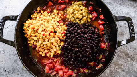 Corn, beans, tomatoes, and green chiles in a skillet