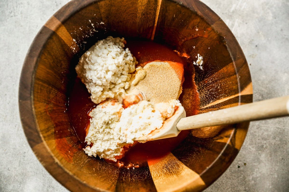 Ingredients for healthy Buffalo chicken dip in bowl before stirring