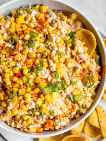 Fritos being dipped in a bowl of Mexican corn dip