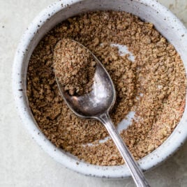 A bowl full of spices with a spoon