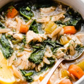 A bowl of healthy lemon chicken orzo soup with spinach