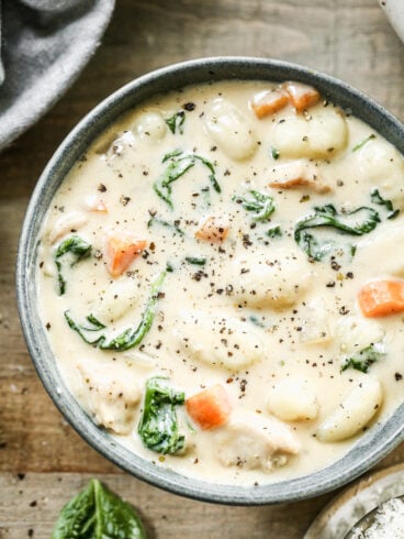 A bowl of chicken gnocchi soup with spinach