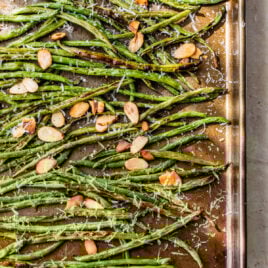A baking sheet with green beans and almonds