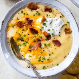 a bowl of cheesy crockpot potato soup from scratch with a spoon