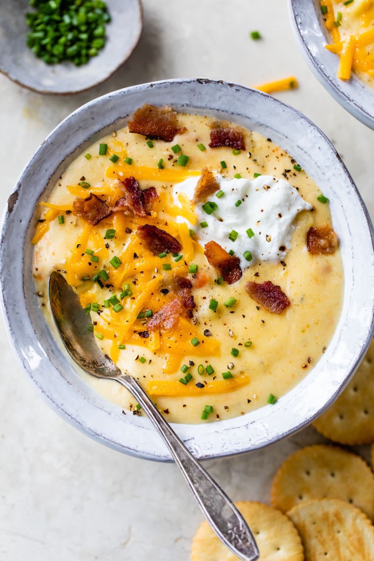 a bowl of cheesy crockpot potato soup from scratch with a spoon