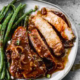 sliced juicy crockpot pork chops on a plate