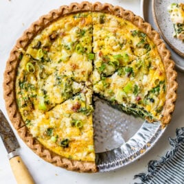 Easy quiche with spinach, cheese, and ham in a store bought pie crust with a slice cut out