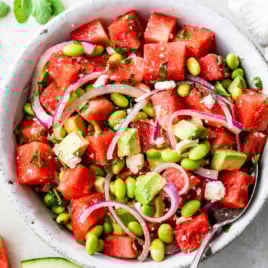 a bowl of watermelon salad with feta, mint, and red onions